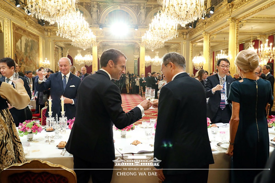 문재인 대통령이 15일(현지시간) 프랑스 파리 대통령궁에서 열린 국빈만찬에서 에마뉘엘 마크롱 프랑스 대통령과 건배하고 있다. 