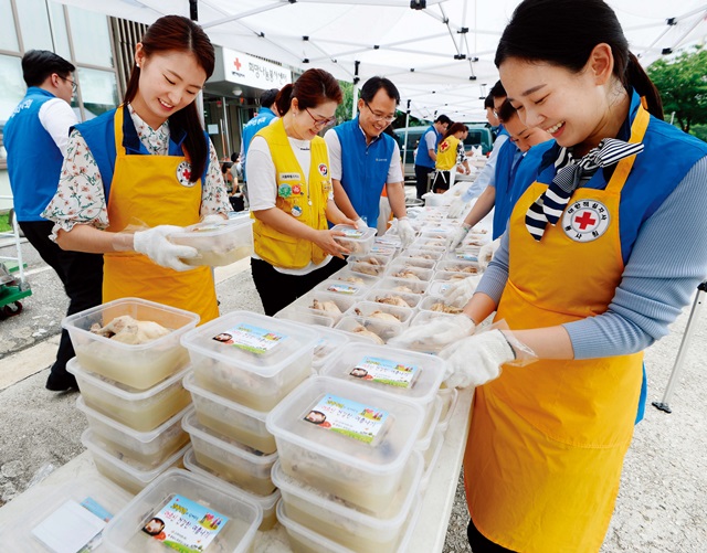 7월 12일 오전 서울 노원구 중랑노원희망나눔봉사센터에서 열린 ‘어르신 건강한 여름나기 초복행사’에서 대한적십자사 서울특별시지사 봉사자들과 고려아연 임직원들이 조리한 삼계탕을 포장하고 있다. 이날 행사에서는 준비한 삼계탕 140인분과 밑반찬을 결연 대상자 가정을 직접 방문해 전달했다. 