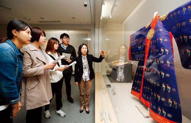 2015년 10~12월 대구 계명대 행소박물관에서 개최된 ‘조선 왕실의 여인 특별전’에서 학생들이 학예사의 설명을 들으며 영친왕비의 옷을 감상하고 있다.