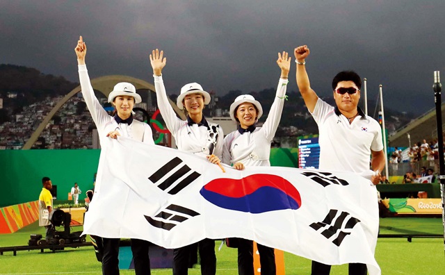  ‘올림픽 8연패’ 신화를 일궈낸 한국 여자 양궁 대표팀이 태극기를 들고 인사하 고 있다. 왼쪽부터 기보배·최미선·장혜진 선수, 양창훈 감독. ⓒ뉴시스 
