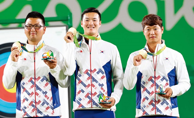  8년 만에 금메달 을 탈환한 한국 남자 양궁 대표팀의 김우진, 구본찬, 이승윤 선수(왼쪽부터)가 금메 달을 들고 포즈를 취하고 있다. ⓒ뉴시스 