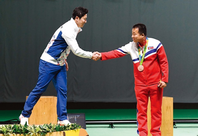 남자 사격 50m 권총 결선에서 금메달을 획득한 진종오 선수가 시상대에서 동메달을 딴 북한의 김성국 선수와 악수하고 있다.
