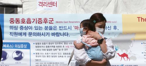 서울대학교 응급실 입구에 설치된 메르스 의심환자 격리센터 앞으로 마스크를 쓴 채 아이를 안고 있는 시민