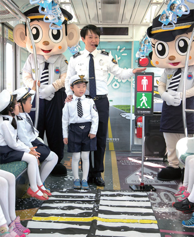 부산도시철도 호포 차량사업소에서 어린이들이 경찰테마열차를 타고 경찰에게 안전교육을 받고 있는 모습