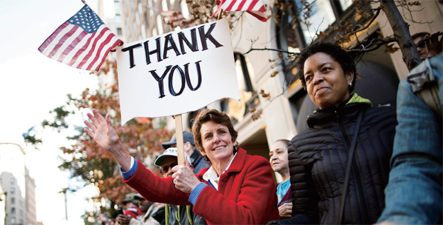 미국 재항군인의 날을 맞아 한 여성이 감사의 뜻을 전하는 플래카드를 펼쳐 보이고 있다.