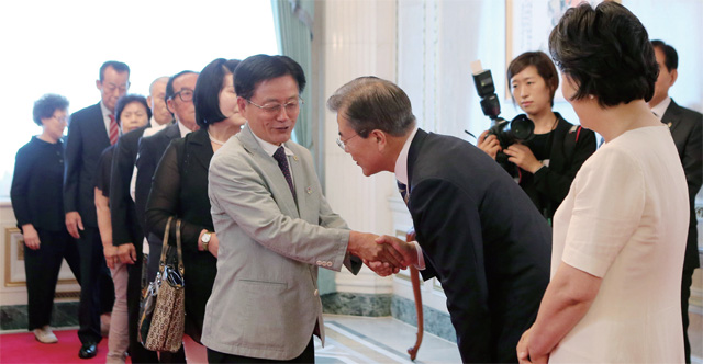 청와대 영빈관에서 열린 '국가유공자 및 보훈가족과의 따뜻한 오찬'행사에서 문재인 대통령이 참석한 국가유공자들을 허리 숙여 인사하고 있다.