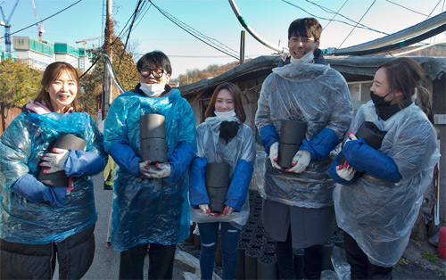 반복되는 작업에도 연신 미소를 띠며 연탄을 운반하고 있는 자원봉사자들