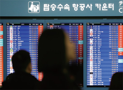 짙은 안개로 항공기 운항 차질이 이어진 2017년 12월 24일 인천국제공항 알림 전광판에 지연 표시가 들어와 있다