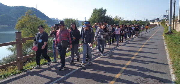 김영진 한독 회장과 직원들이 팔당댐 길을 따라 걸으며 가벼운 담소를 나누고 있다.