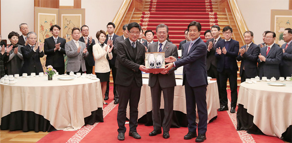 문재인 대통령이 벤처기업 및 소상고인과의 대화에서 (주)공사박사 대표예게 성공을 기원하며 '운동화'를 선물하고 있다.