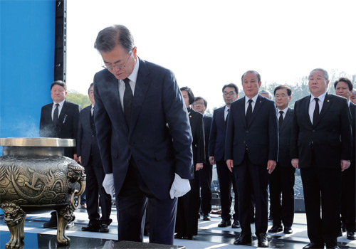 문재인 대통령이 4월 19일 서울 국립 4 19 기념탑에 헌화 분항한 뒤 묵념을 하고 있다.