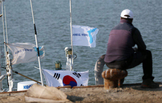 한 연평도민이 어선에 매달린 서해 5도 한반도기를 보고 있다.