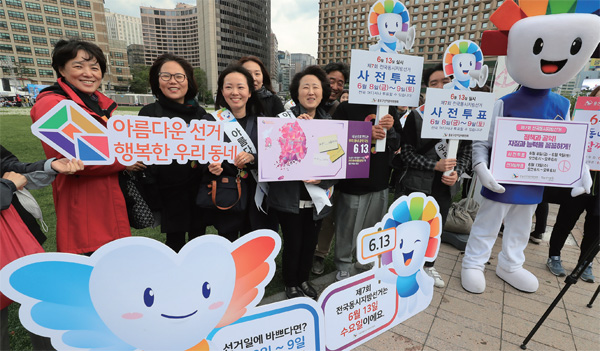 지난 5월 3일 서울광장에서 열린 민주선거 70주년 및 제7회 유권자의 날 기념 아름다운 지방선거 홍보 캠페인에서 참가자들이 사전투표 안내 등이 적힌 피켓을 들고 있다.