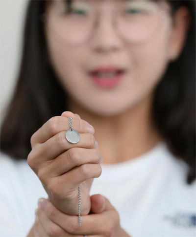 8월 13일 인천국제공항에서 2018 자카르타·팔렘방 아시안게임에 출전하는 조정 남북단일팀의 송지선이 여자 경량급 더블스컬에 함께 출전하는 북한 김은희에게 선물한 것과 똑같은 목걸이를 취재진에게 보여주고 있다.