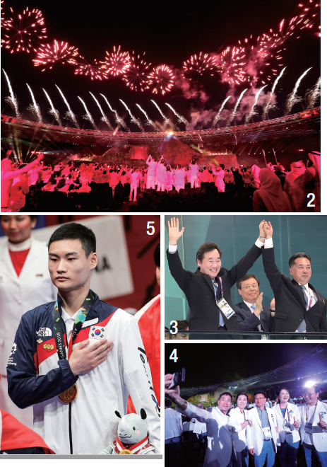 화려한 불꽃이 개회식 주변을 수놓고 그 모습을 각국 선수단이 촬영하고 있다.