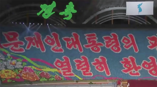 평양 능라도 경기장에서 카드 섹션 장면. 매우 화려하고 강렬한 색채와 글씨체로 디자인 되었다.