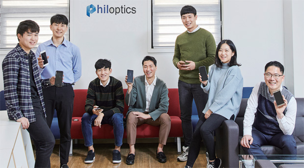 필옵틱스 직원들이 스마트폰을 들고 있다. 스마트폰의 액정은 필옵틱스의 레이저커팅 기술로 만들었다. 필옵틱스 직원들이 스마트폰을 들고 있다. 스마트폰의 액정은 필옵틱스의 레이저커팅 기술로 만들었다.