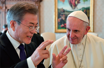 문재인 대통령이 무언가 이야기를 건네자 프란치스코 교황이 웃으면서 듣고 있다.