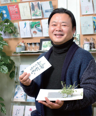 김명진 협동조합온리 이사장이 새벽에 나온 수제 씨앗카드 '종이정원'을 들고 환하게 웃고 있다. 김명진 협동조합온리 이사장이 새벽에 나온 수제 씨앗카드 '종이정원'을 들고 환하게 웃고 있다.