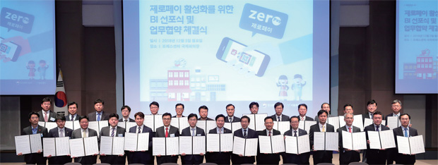 지난 12월 3일 서울 중구 한국프레스센터 국제회의장에서 열린 제로페이 BI 선포식 및 업무협약식에 참석한 홍종학 중소벤처기업부 장관과 박원순 서울시장, 프랜차이즈 업계 대표들이 업무협약서를 들고 기념촬영을 하고 있다.