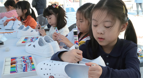 지난 11월 2일 서울 광화문광장에서 돈암초등학교 1학년 어린이들이 캄보디아의 빈곤 청소년들에게 전달할 ‘세상에 하나뿐인 운동화’를 만들고 있다.