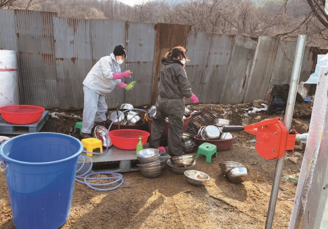 봉사자들이 150마리 개들의 사료 그릇을 닦고 있다. 인천 시내보다 7℃ 정도 기온이 낮은 계양산에선 겨울철 설거지를 하는 것조차 쉽지 않다.