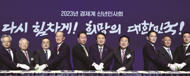 윤석열 대통령이 1월 2일 서울 코엑스에서 열린 ‘2023년 경제계 신년인사회’에서 참석자들과 떡케이크를 자르고 있다. 사진 대통령실