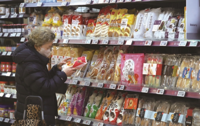 대형마트에서 장을 보는 한 여성이 식품소비기한을 확인하고 있다. 사진 뉴시스