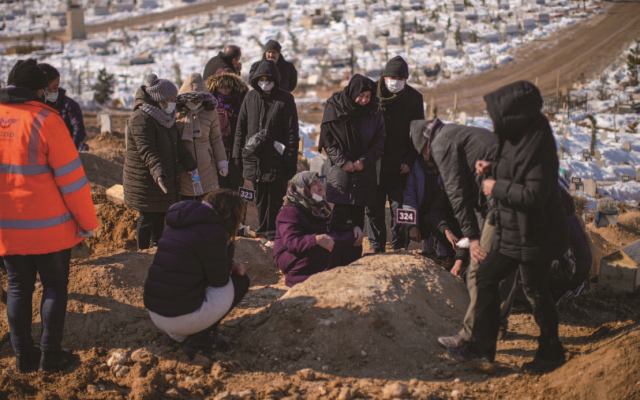 튀르키예 말라티아의 세히르 공동묘지에서 유족들이 지진으로 숨진 가족 세 명의 시신을 매장하고 있다. 사진 뉴시스