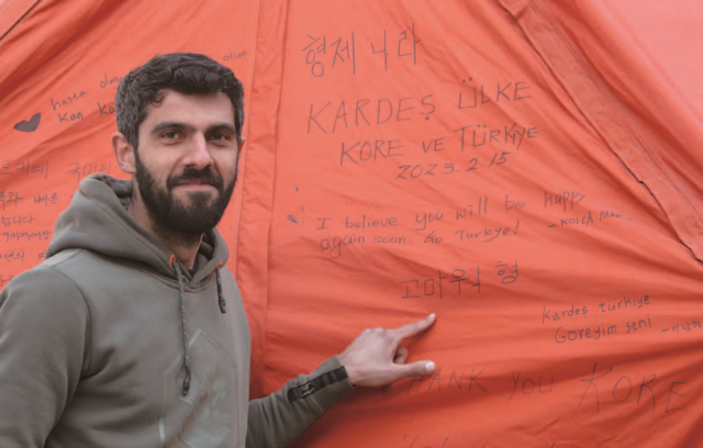 2월 14일 오후(현지시간) 튀르키예 하타이주 안타키아 아나돌루 고등학교에 마련된 대한민국 긴급구호대(KDRT) 숙영지 텐트에 튀르키예인 엠레가 자신이 직접 쓴 감사문구 ‘고마워 형’ 앞에서 기념촬영을 하고 있다. 사진 뉴시스