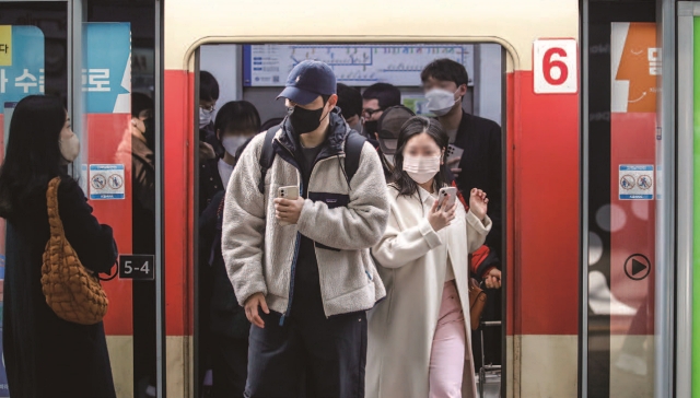 3월 20일부터 대중교통과 대형시설 내 개방형 약국에서 마스크 착용 의무가 해제된다. 사진은 마스크를 쓴 시민들이 전철에서 내리고 있는 모습. 사진 뉴시스