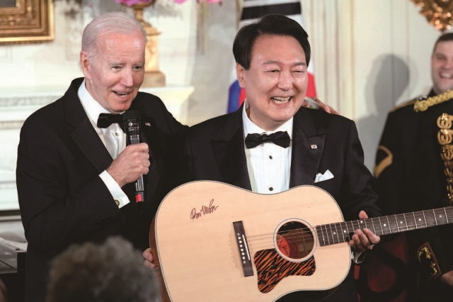 한미 정상회담이 끝나고 열린 국빈 만찬에서 윤석열 대통령이 조 바이든 미국 대통령이 선물한 기타를 들고 있다. 사진 뉴시스