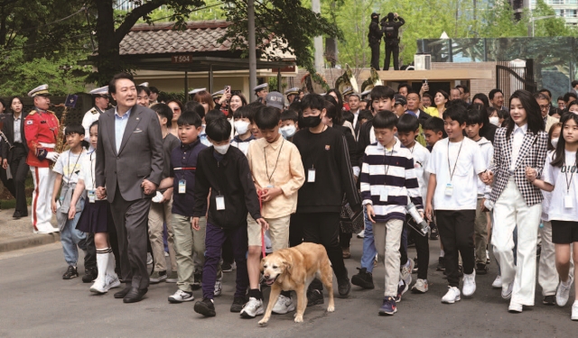 윤석열 대통령이 5월 4일 개장한 용산어린이정원 개방 행사에 참석해 어린이들과 손을 잡고 입장하고 있다. 사진 뉴시스