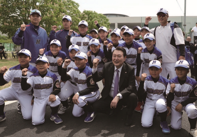 윤석열 대통령이 5월 10일 서울 용산어린이정원 야구장을 방문해 서울 화곡초등학교 야구단 선수들과 기념촬영하고 있다. 사진 뉴시스