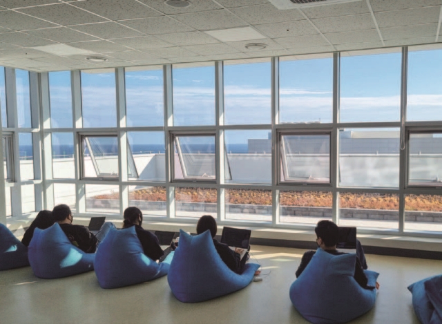 제주도 서귀포시에 조성한 워케이션 공공오피스. 바다가 보이는 창 앞에서 직원들이 편히 앉아 노트북으로 업무를 하고 있다. 사진 조선DB