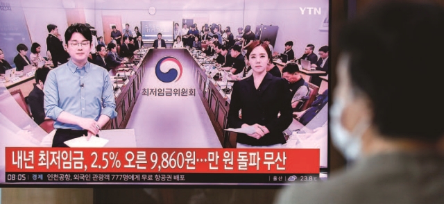 7월 19일 서울 중구 서울역 대합실에서 시민들이 내년도 최저임금 결정 관련 뉴스를 바라보고 있다. 사진 뉴시스