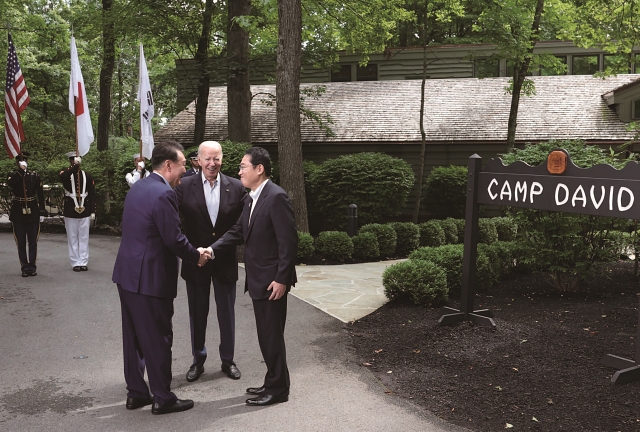 윤석열 대통령이 8월 18일(현지시간) 미국 메릴랜드주에 위치한 미 대통령 별장 캠프 데이비드에서 한·미·일 정상회의에 앞서 조 바이든 미국 대통령, 기시다 후미오 일본 총리와 만나 인사를 나누고 있다. 사진 뉴시스
