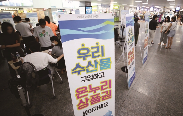 8월 6일 서울 노량진수산시장에서 수산물을 구입한 시민들이 온누리상품권 환급을 받고 있다. 사진 뉴시스