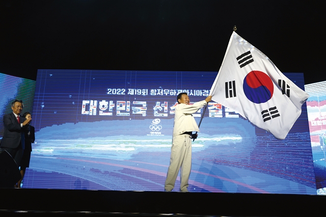 9월 12일 서울 올림픽공원에서 열린 2022 항저우 아시안게임 선수단 결단식에서 최윤 선수단장이 태극기를 흔들고 있다. 사진 뉴시스
