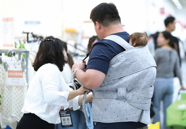 10월 5일 서울 강남구 코엑스에서 열린 베이비페어에서 관람객들이 아기띠 용품을 착용하고 있다. 사진 뉴시스
