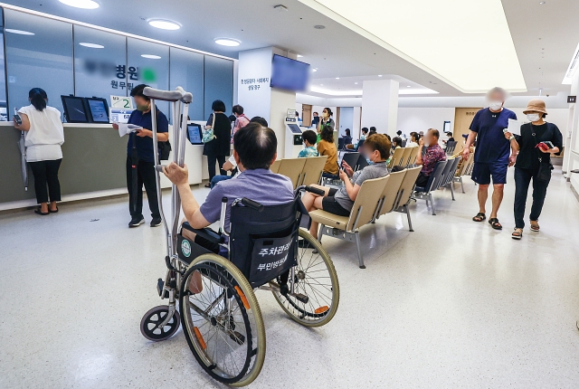 지난 7월 24일 서울시내 한 병원 원무과에서 시민들이 접수를 기다리고 있다. 사진 뉴시스