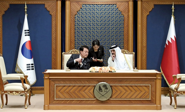 윤석열 대통령이 10월 25일(현지시간) 카타르 도하 아미리 디완 왕궁에서 열린 한·카타르 양해각서(MOU) 서명식을 마친 뒤 타밈 빈 하마드 알 싸니 국왕과 대화하고 있다. 사진 뉴시스