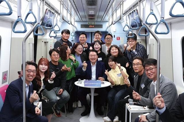 윤석열 대통령이 11월 6일 경기 화성시 동탄역 GTX-A 열차에서 열린 '광역교통 국민간담회'에서 참석자들과 기념촬영을 하고 있다. 사진 대통령실