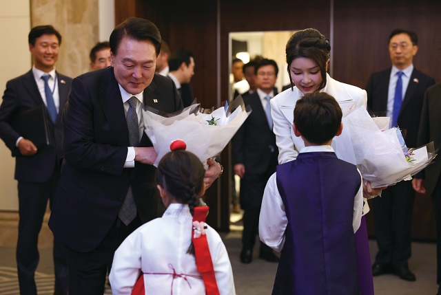 영국을 국빈 방문한 윤석열 대통령과 부인 김건희 여사가 11월 20일(현지시간) 런던 시내 한 호텔에서 열린 동포 초청 만찬 간담회에서 화동으로부터 꽃다발을 받고 있다. 사진 뉴시스