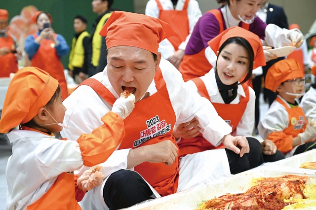 윤석열 대통령이 11월 27일 경기 고양시 킨텍스에서 열린 ‘나눔과 봉사의 국민 대통합 김장 행사’에서 어린이가 담근 김치를 맛보고 있다. 사진 대통령실