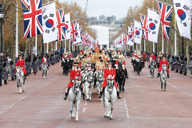 영국을 국빈 방문한 윤석열 대통령이 11월 21일(현지시간) 런던 호스가즈 광장에서 열린 공식 환영식을마 친 뒤 찰스 3세 국왕과 함께 마차를 타고 버킹엄궁 앞 도로를 행진하고 있다.
