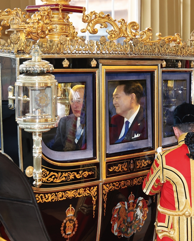 영국을 국빈 방문한 윤석열 대통령이 11월 21일(현지시간) 찰스 3세 국왕과 함께 마차를 타고 런던 버킹엄궁으로 들어서고 있다. 사진 뉴시스