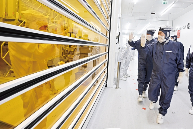 윤석열 대통령이 12월 12일(현지시간) 벨트호벤에 있는 ASML 본사에서 빌렘-알렉산더 네덜란드 국왕과 함께 클린룸을 둘러보며 작업 중인 근로자에게 손 흔들어 인사하고 있다. 사진 뉴시스
