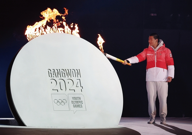 프리스타일 스케이팅 선수 이정민이 강원2024 개회식에서 성화에 불을 붙이고 있다. 사진 뉴시스