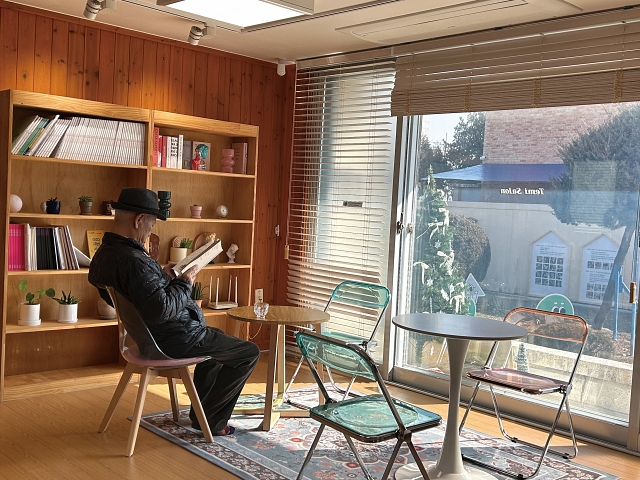 볕이 스며드는 테미살롱 1층 거실에서 책을 읽고 있는 시민. 